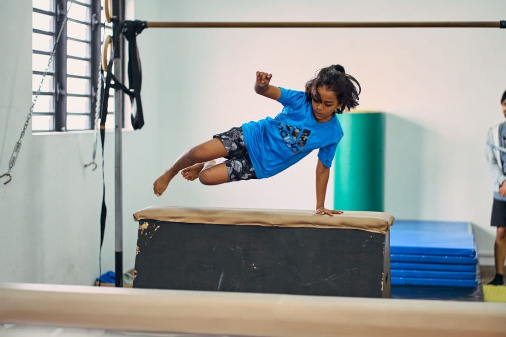 Boy vaulting over a padded box